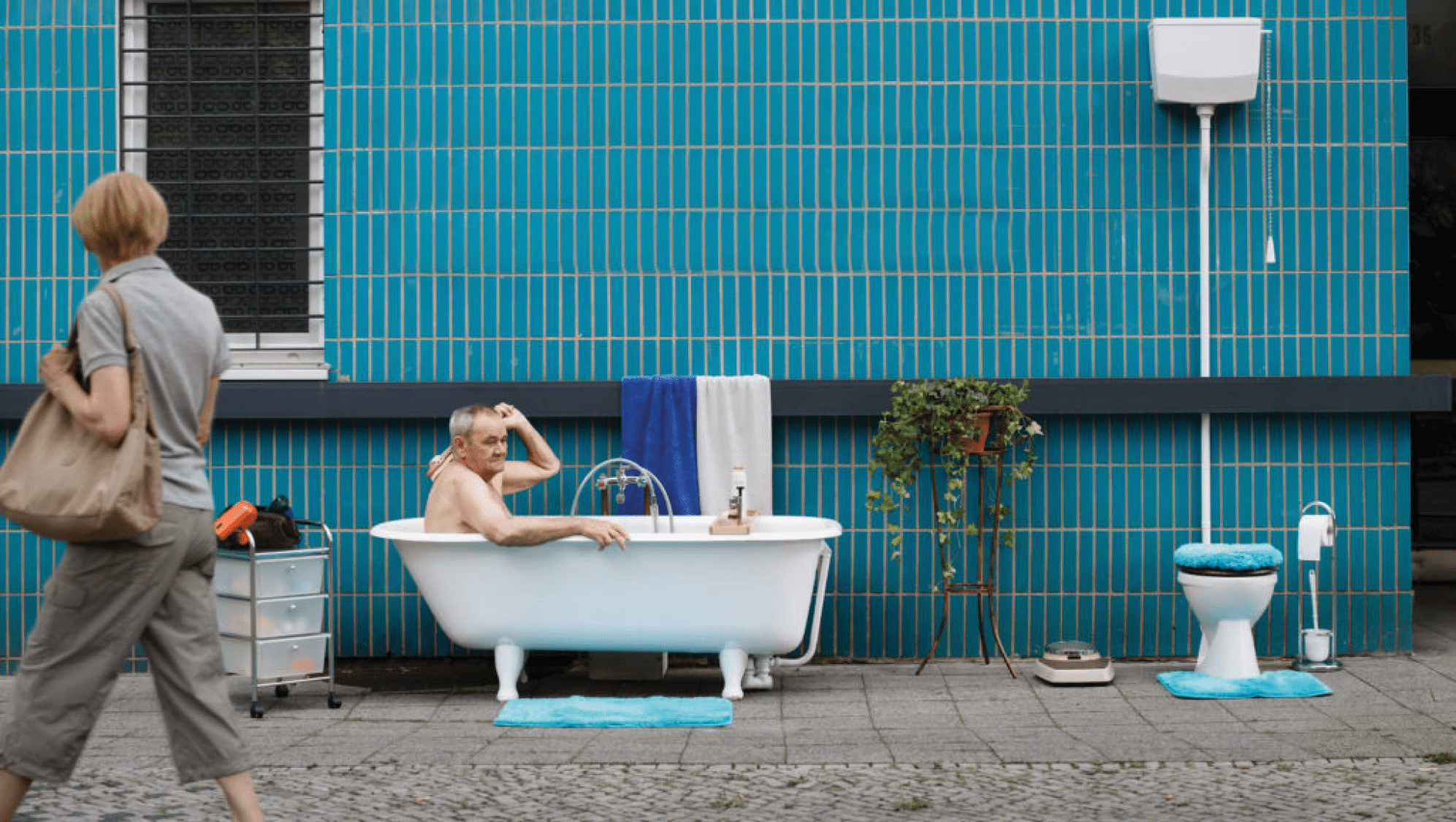 Ein älterer Mann in der Badewanne auf der Straße. Teil der Kampagne gegen Wohnungsnot von der Berliner Agentur glow für den Deutschen Caritasverband.